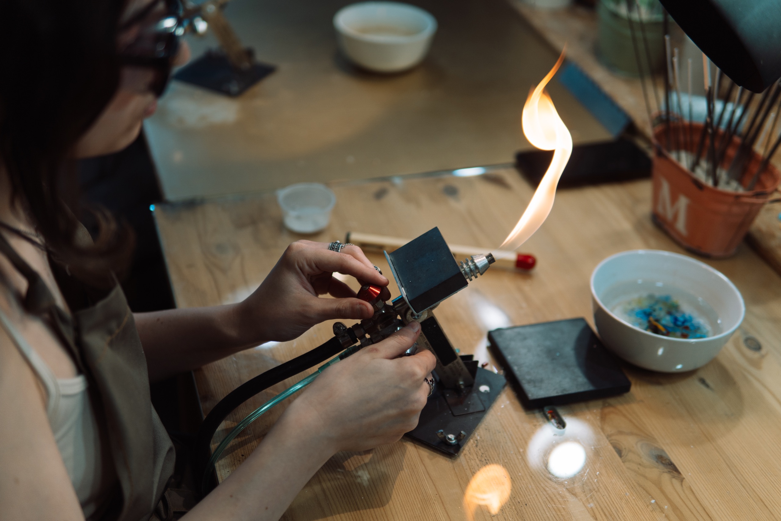 Участница мастер-класса GlassBaker работает со стеклом в пламени