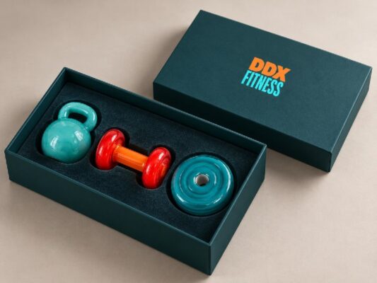 Фирменная коробка DDX Fitness со стеклянными гирей и гантелью внутри