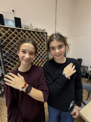 Участницы показывают браслеты, собранные из стеклянных бусин